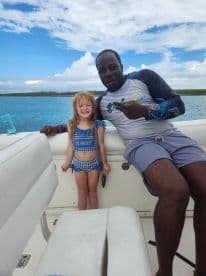 A joyful moment captured on a boat with a smiling child and adult, showcasing family fun on the water.