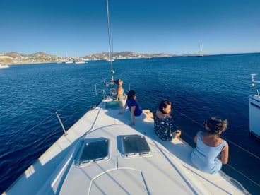 A group of friends relaxes on the deck of a sailboat, enjoying the serene ocean views — a perfect moment for sailing enthusiasts and social gatherings on the water.