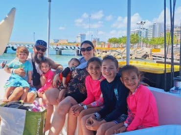 A joyful family poses together on a boat, enjoying a fun day out on the water with children, perfect for family adventures and memorable experiences.