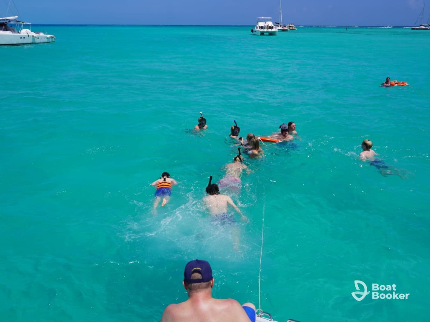 A lively group enjoys snorkeling in the crystal-clear turquoise waters, creating unforgettable memories on their aquatic adventure.