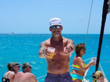 A lively scene aboard a yacht with guests enjoying drinks and the sun, capturing the essence of a fun day on the water.
