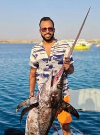 A proud angler displays his impressive catch of a large fish while enjoying a day on the water — a perfect moment for fishing enthusiasts.