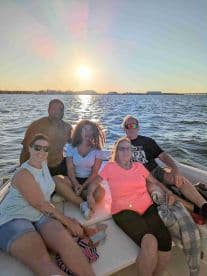 A group of friends enjoys a beautiful sunset on a boat, creating unforgettable memories together on the water.