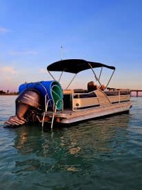 A beautiful pontoon boat glides through calm waters, showcasing its sleek design and spacious layout, perfect for leisurely outings on the water.