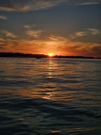 A stunning sunset over calm waters, creating a picturesque scene perfect for evening boat trips and relaxation.