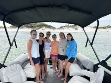 A cheerful group of friends poses together on a boat, enjoying a day out on the water — perfect for celebrations and memorable outings.