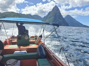 A boat navigates through stunning waters with dramatic mountain scenery in the background, showcasing an adventurous day on the water.