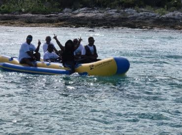 A lively group enjoys a fun ride on a banana boat, showcasing the excitement of water activities in a beautiful setting.