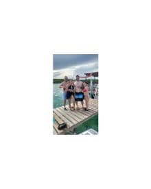A cheerful group poses for a photo on a dock, ready for a fun day of swimming and relaxation in the water.