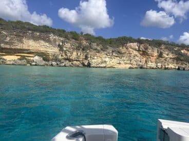 A stunning view of a rocky coastline against crystal-clear turquoise waters, perfect for exploring the natural beauty of the area.