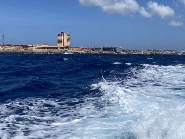 A scenic view of the coastline with a vibrant city backdrop, showcasing the beautiful ocean waves — perfect for capturing the essence of a boating adventure.