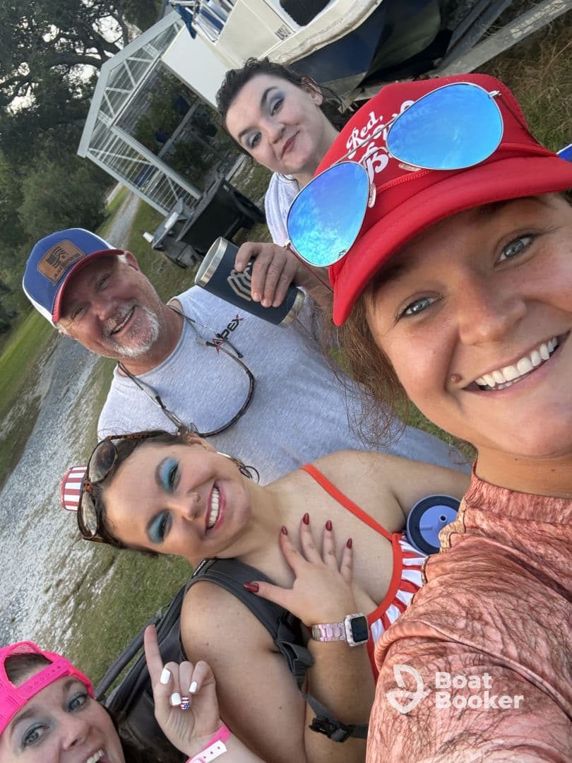 A cheerful group of friends poses for a selfie, capturing the excitement of their boating adventure together. Perfect for showcasing fun moments on the water.