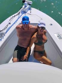 A couple enjoys a sunny day on the boat, capturing a perfect moment of relaxation and fun on the water.