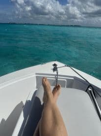 A serene moment on a boat with feet resting on the deck, showcasing the stunning turquoise waters — perfect for relaxation and enjoying the ocean breeze.