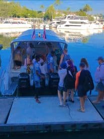 A lively group boards a boat at the marina, ready for an exciting adventure on the water. Perfect for group outings and tours.
