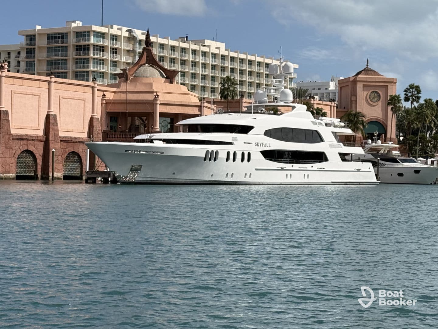 A stunning yacht named 'Skyfall' docked at a picturesque marina, showcasing luxury and elegance against a vibrant backdrop.