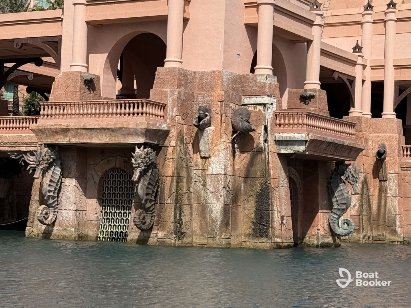 An architectural feature with seahorse sculptures and a water backdrop, showcasing intricate design elements.