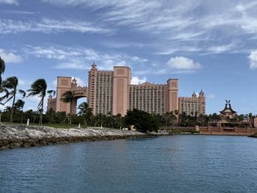 A stunning view of the iconic Atlantis Resort in the Bahamas, showcasing its impressive architecture against a backdrop of clear blue skies and tranquil waters.