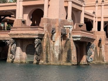 An architectural feature with seahorse sculptures and a water backdrop, showcasing intricate design elements.