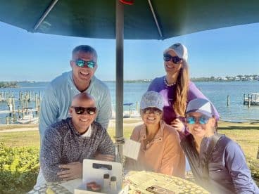 A cheerful group of friends enjoys a sunny day by the waterfront, perfect for social gatherings and celebrations.