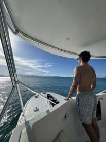 A man enjoys the stunning ocean view from the deck of a boat, capturing the essence of a relaxing day on the water.