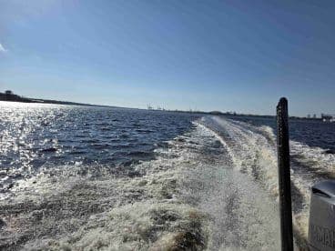 A dynamic view of a boat in motion, showcasing the shimmering water and wake as it navigates through the waterway, perfect for capturing the essence of boating adventures.