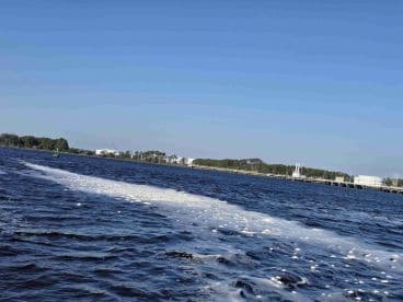 An unclear image of water with some foam and distant land features, lacking identifiable subjects or clarity.