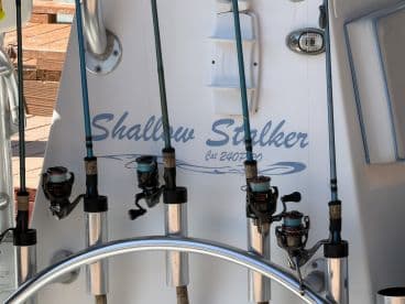 A close-up view of fishing rods and reels mounted on a boat, showcasing the essential gear for a successful fishing trip.