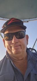 A close-up selfie of an individual on a boat, capturing a moment on the water.