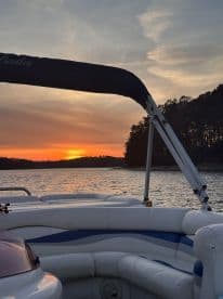 A serene sunset view from a Bentley pontoon boat, showcasing the tranquil waters and surrounding nature — perfect for evening cruises.