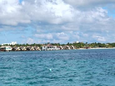 A scenic view of a shoreline with resorts and palm trees, captured from the water. The image lacks clarity and detail.