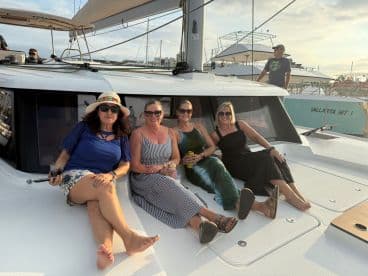 A group of friends relaxes on the deck of a yacht, enjoying drinks and each other's company — perfect for a fun day on the water.
