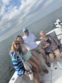 A joyful family poses together on a boat, enjoying their time on the water — perfect for creating lasting memories during a fun day out.