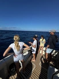 A group of friends and family enjoy a fishing trip on the open ocean, showcasing the excitement of a day spent on the water.