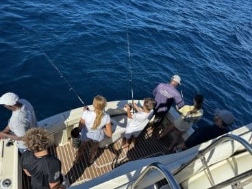 A group of friends and family enjoy a fishing trip on the open water, showcasing the excitement of on-water activities and bonding moments.