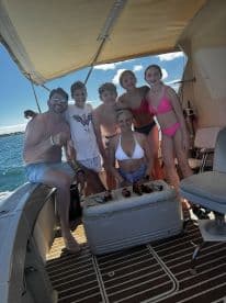 A joyful family poses on a boat after a successful fishing trip, showcasing their catch and enjoying quality time together on the water.