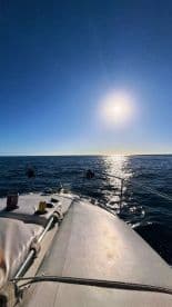 A serene view from the front of a yacht, showcasing the sparkling ocean under a bright sun — perfect for a peaceful day on the water.