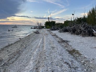 A picturesque view of a coastline at sunset, featuring a boat in the distance, perfect for capturing the beauty of nature and on-water adventures.