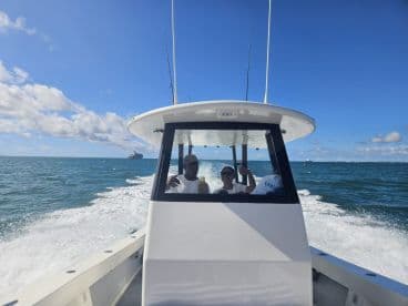 A group of friends enjoys a thrilling ride on a boat, capturing the excitement of a day on the water with stunning views and clear skies.
