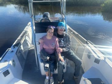 A happy couple enjoys a moment together on a boat, showcasing the perfect setting for a romantic day on the water.