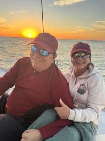 A couple enjoys a romantic moment aboard a sailboat at sunset, capturing the essence of love and adventure on the water.