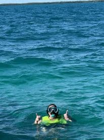 A snorkeler gives a thumbs up while enjoying the vibrant waters, showcasing the excitement of underwater adventures.