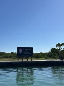 A scenic view of the Boca Chita Key sign in Biscayne National Park, showcasing a beautiful day on the water — a perfect destination for boating adventures.