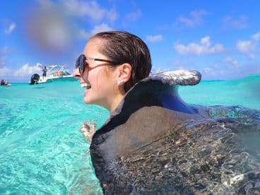 A joyful interaction with a stingray in crystal-clear waters, showcasing the thrill of swimming with wildlife in a tropical paradise.