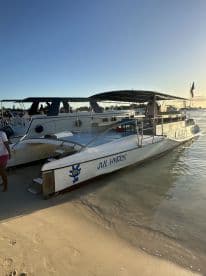 A catamaran named 'Jul Hybris' docked on a sandy beach, showcasing its sleek design against a clear blue sky. Perfect for island adventures and water excursions.