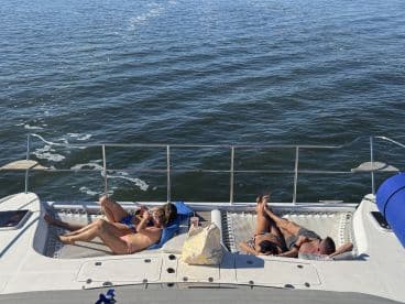 A group of friends relaxes on the deck of a boat, enjoying the sun and water — the perfect setting for a day of leisure on the water.