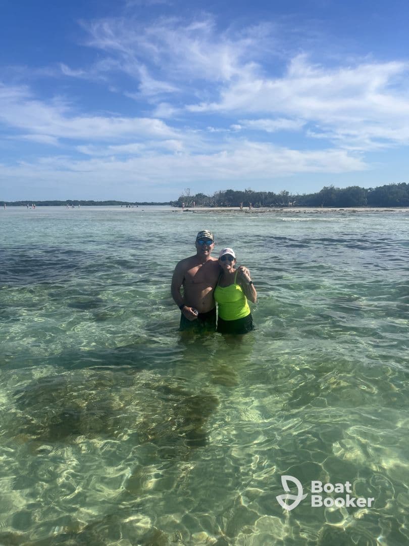 A couple enjoys a refreshing swim in the crystal-clear waters, capturing a perfect moment of fun and relaxation at the beach.