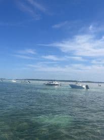 A vibrant scene at a sandbar with multiple boats and people enjoying the water — perfect for a fun day out on the water.