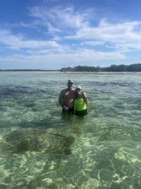 A couple enjoys a refreshing swim in the crystal-clear waters, capturing a perfect moment of fun and relaxation at the beach.