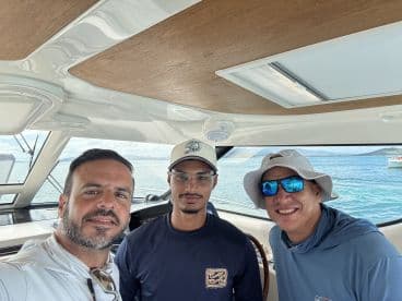 Three friends pose for a selfie inside a boat, capturing a moment of camaraderie on the water. Ideal for showcasing the joy of boating adventures.